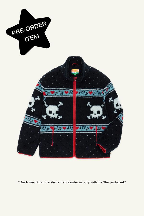 A Black Multi sherpa jacket featuring white skull and crossbones patterns, red hearts, and light blue musical note designs across the chest and sleeves. Black star in top left corner reads "Pre-Order Item."