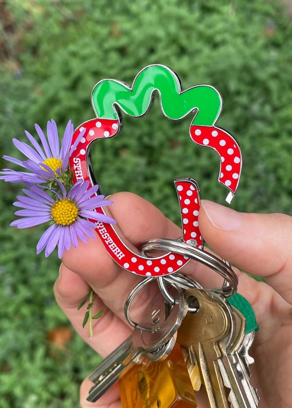 Hand holding a set of keys on a strawberry shaped metal carabiner red.