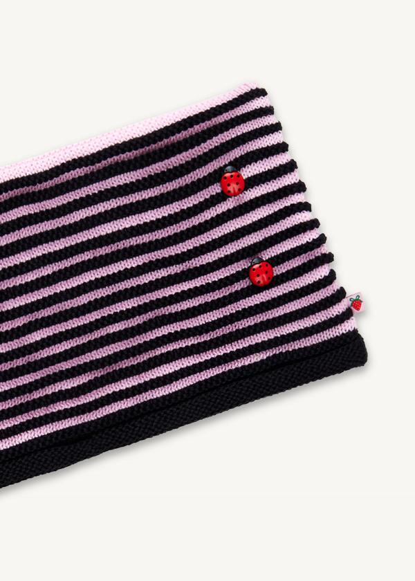 Closeup of detail of a pink and black dimensional striped beanie with scattered ladybug button decorations.