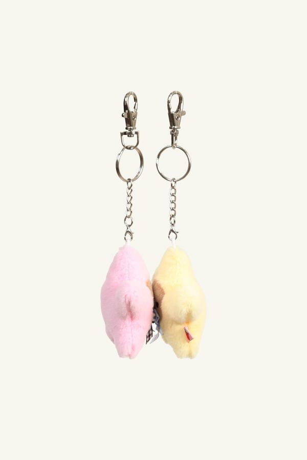 View of set of 2 kissing starbaby keychains in pale yellow and baby pink with gingham bows that can kiss by way of interior magnets in their faces. 