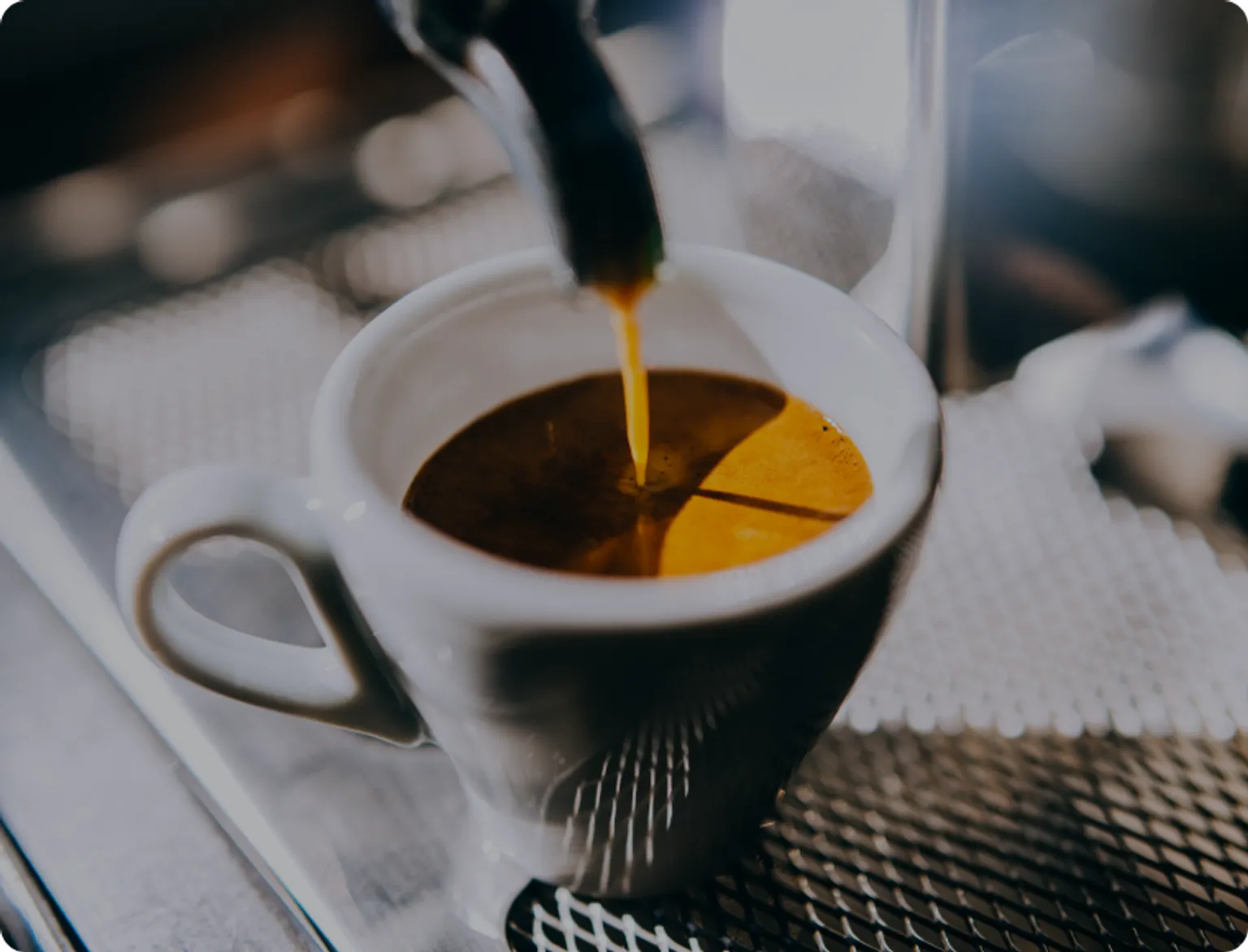 A coffee cup being filled with freshly brewed coffee.