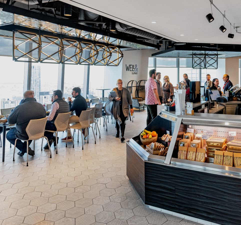 A spacious room with people seated at tables.