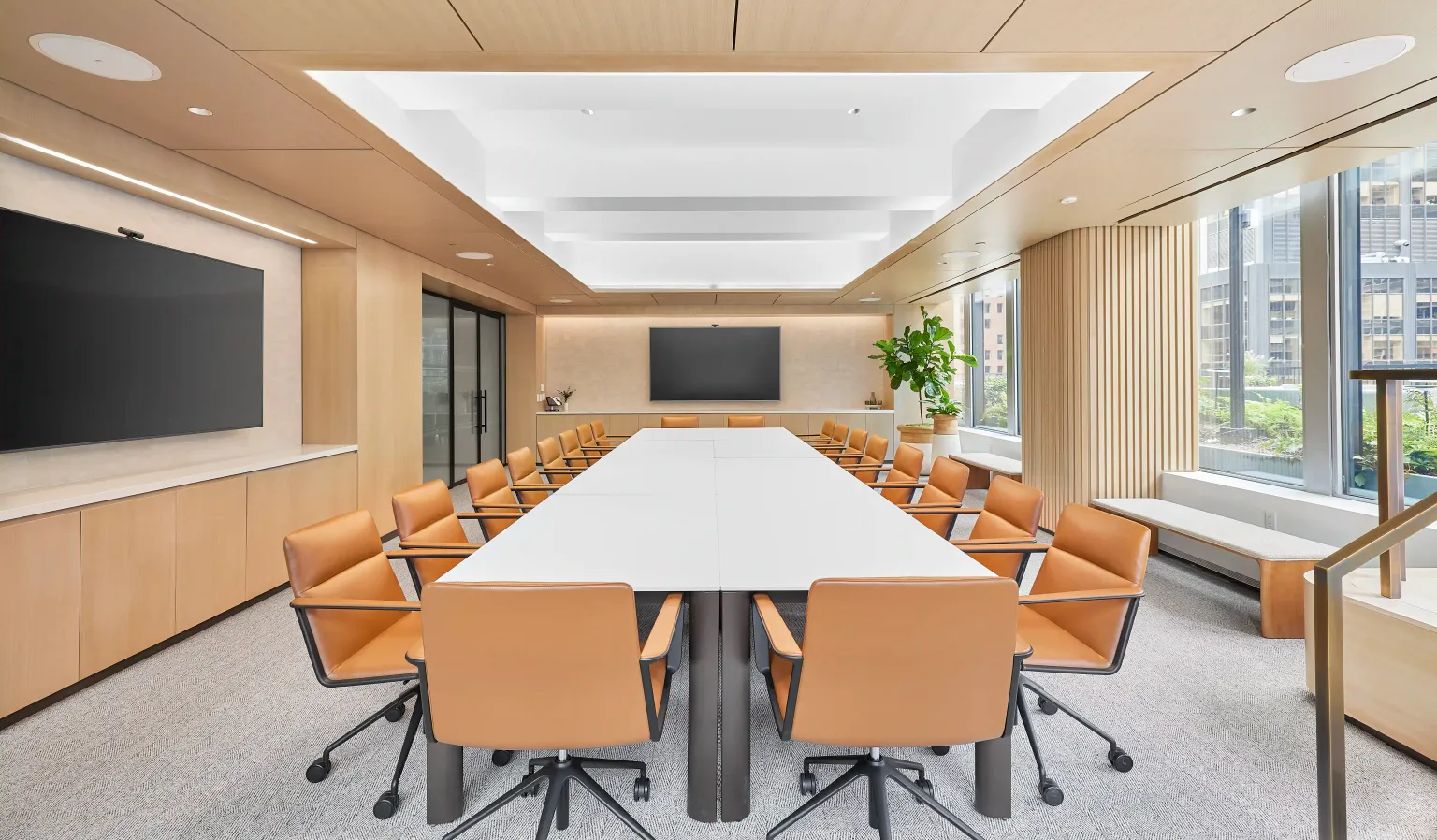 825 Third Ave's modern conference room with white table and vibrant orange chairs.