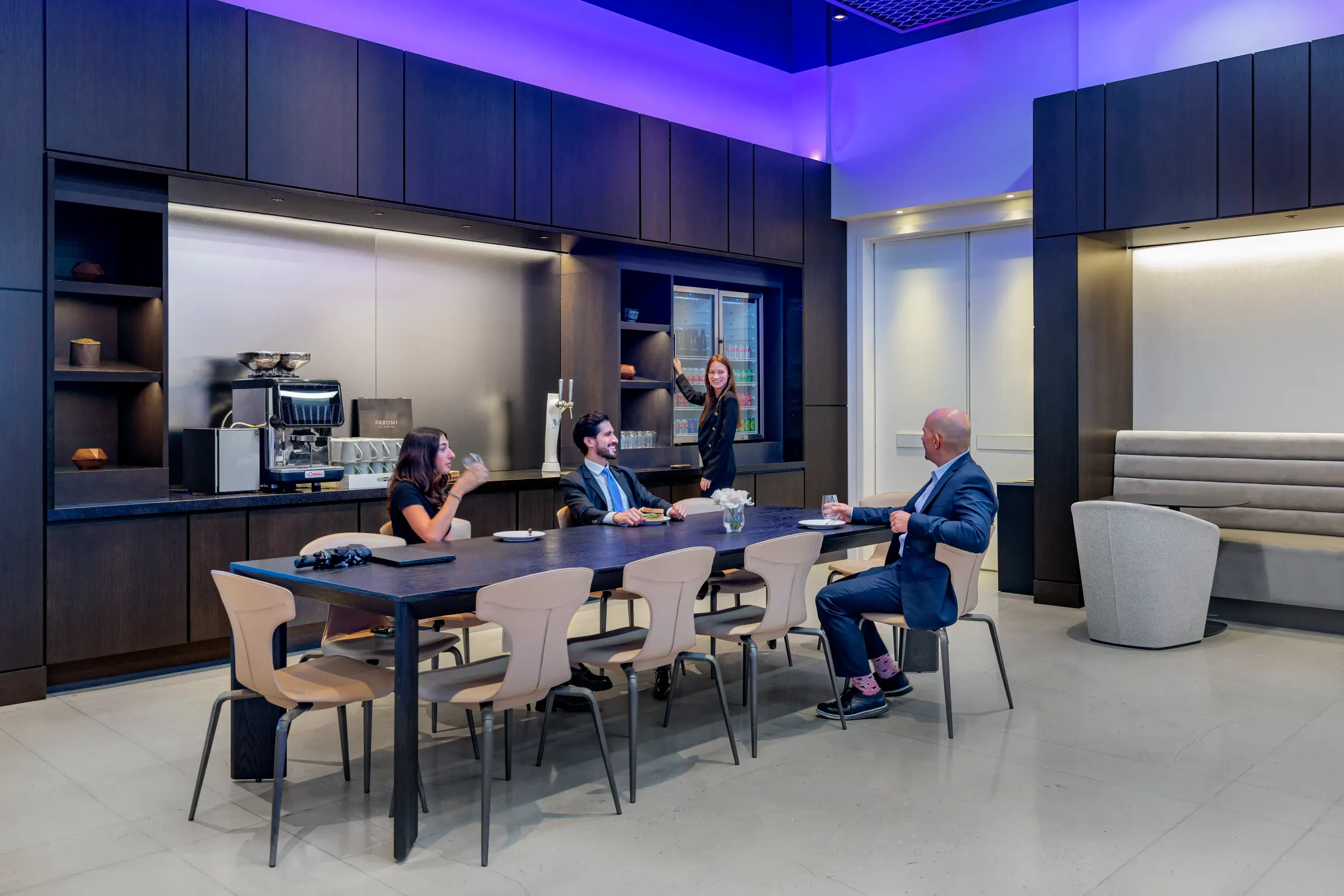 A diverse group of professionals sitting around a table in a contemporary office, engaged in a meeting.
