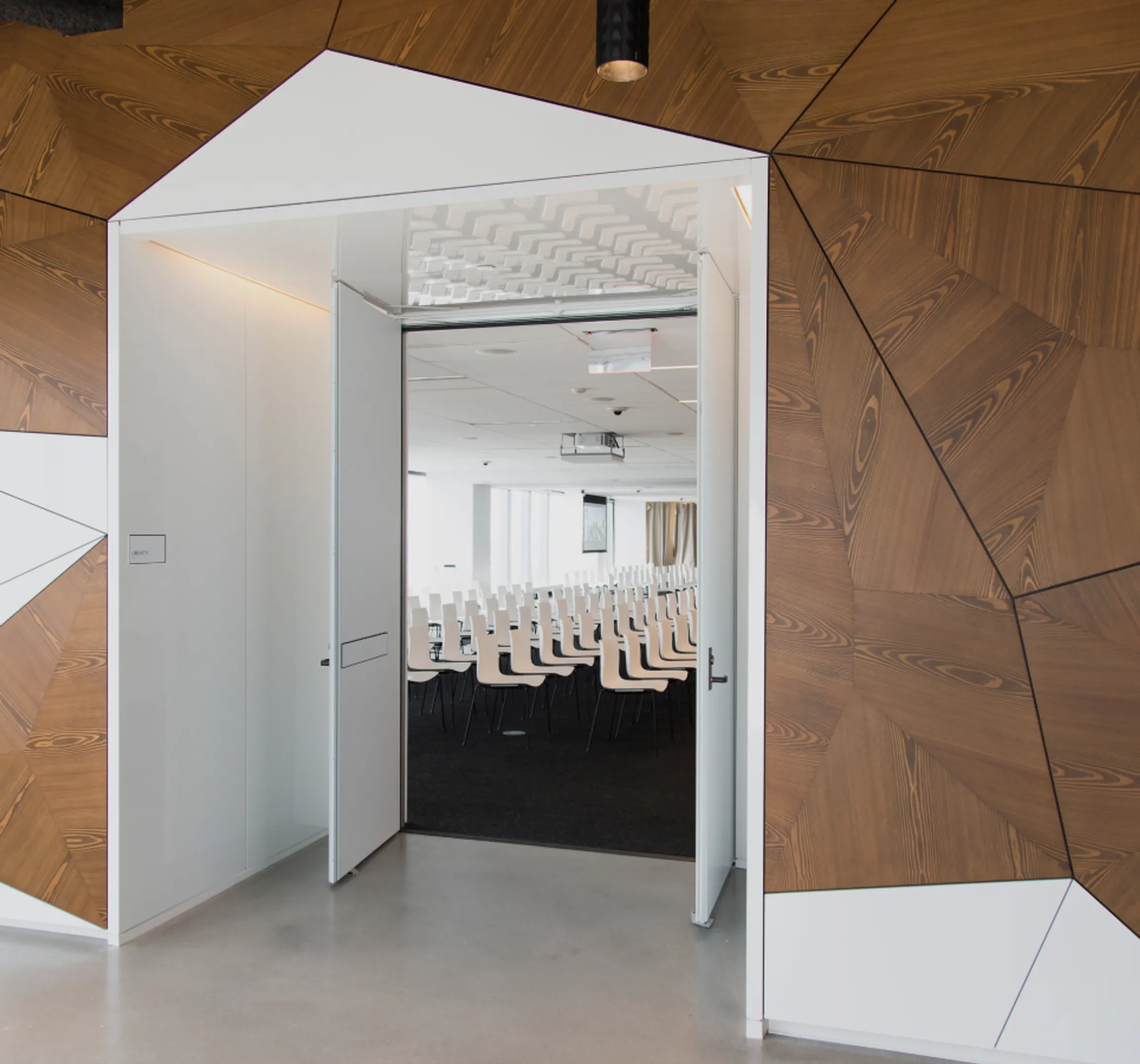 Entrance to a conference room with white chairs and a large windows.