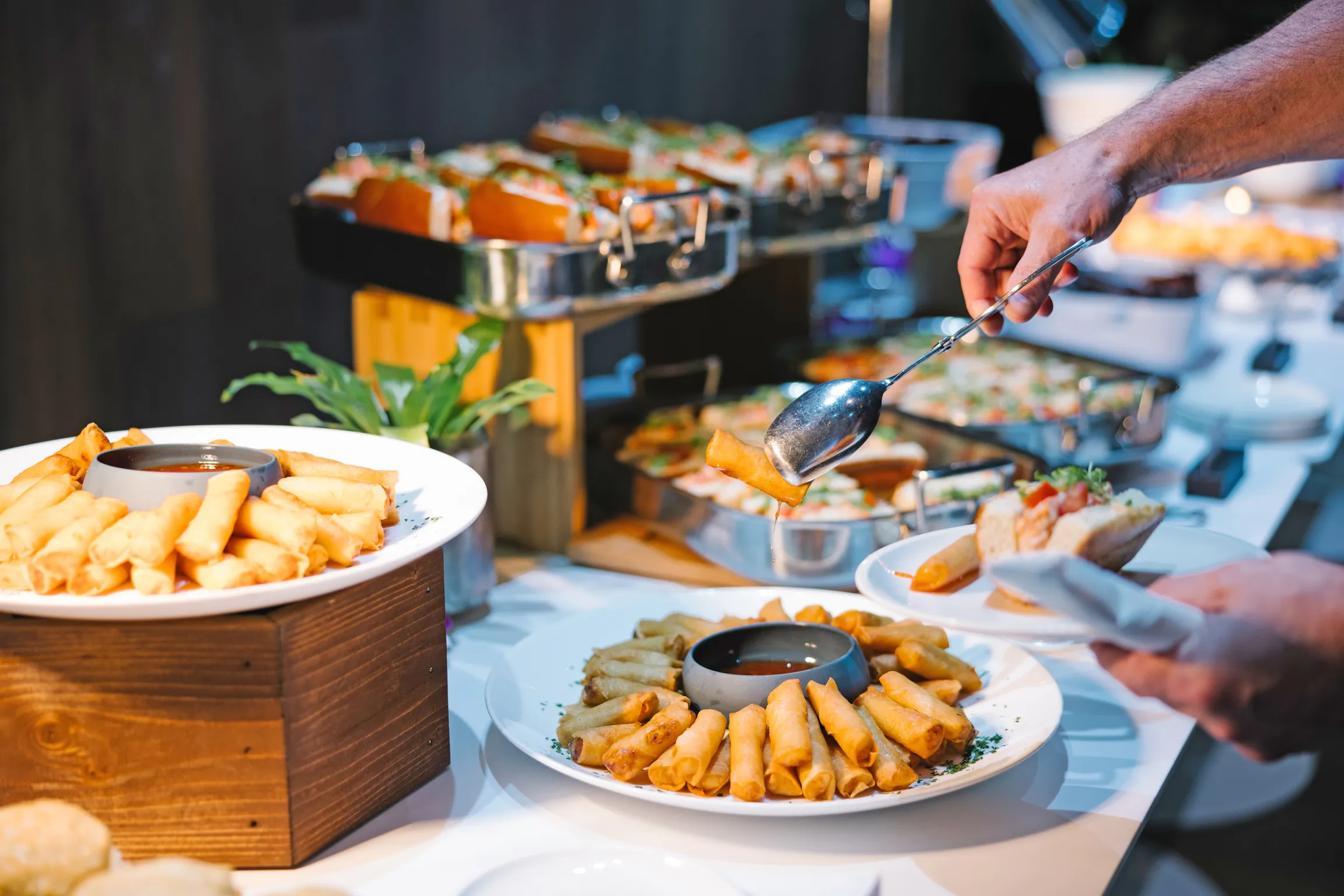 A person serving food on their dish from the catering bar on their corporate event