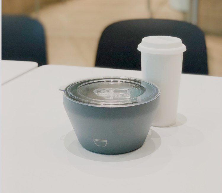 A recycled cup and a food bowl placed on a table.