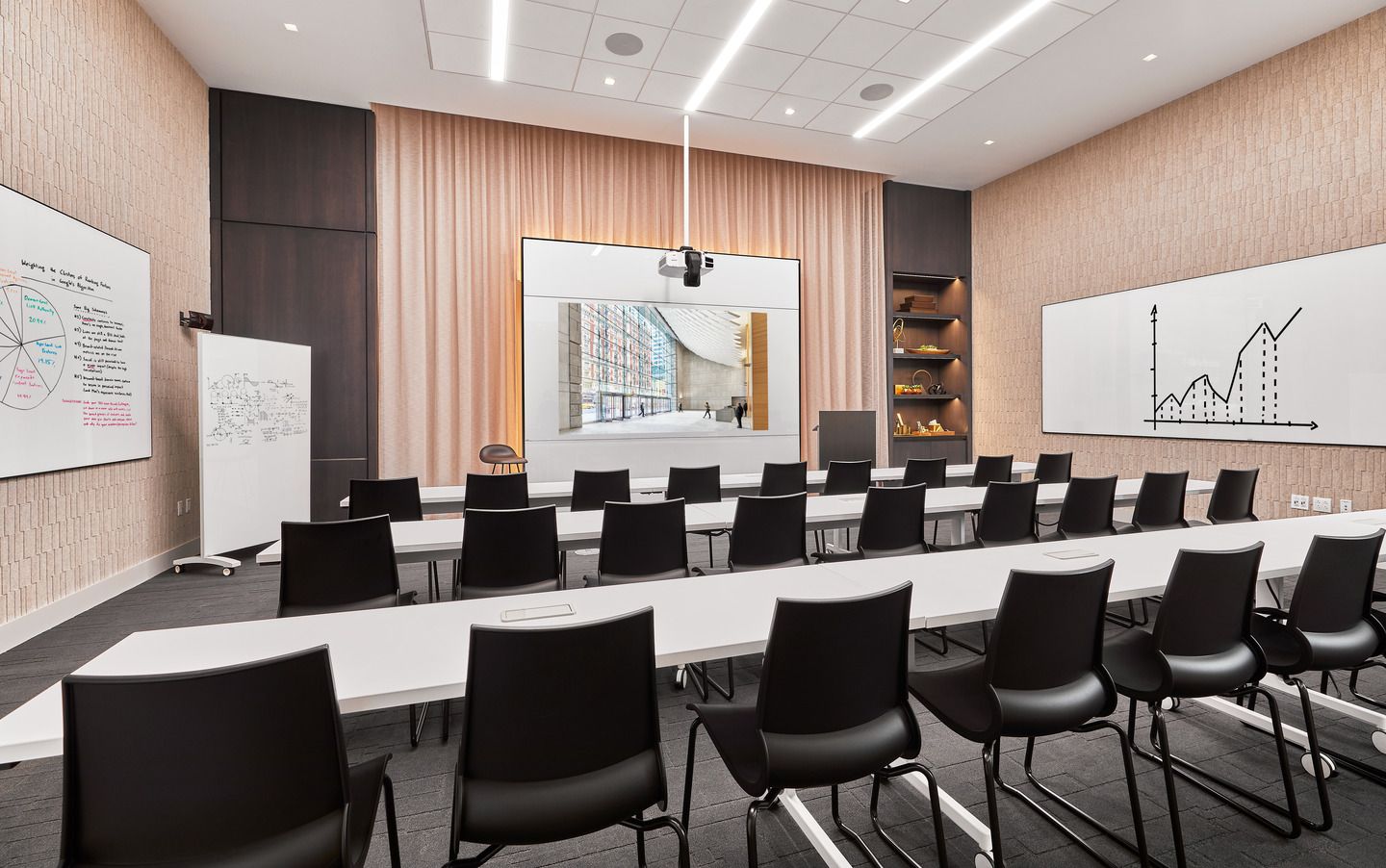A conference room with white chairs and a large window, providing a bright and spacious environment for meetings and discussions.