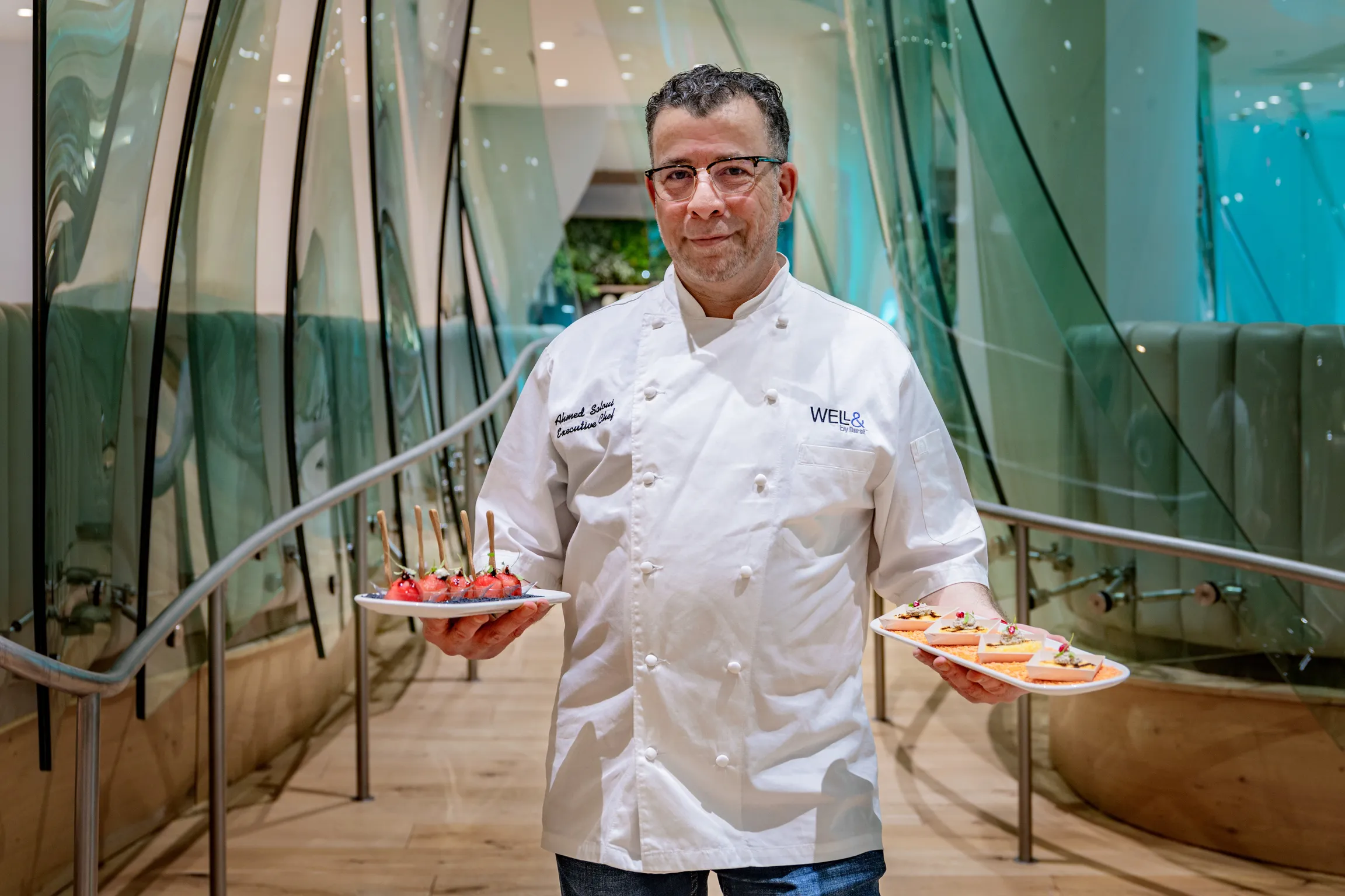 Chef Ahmed displaying a variety of appetizing dishes on plates.
