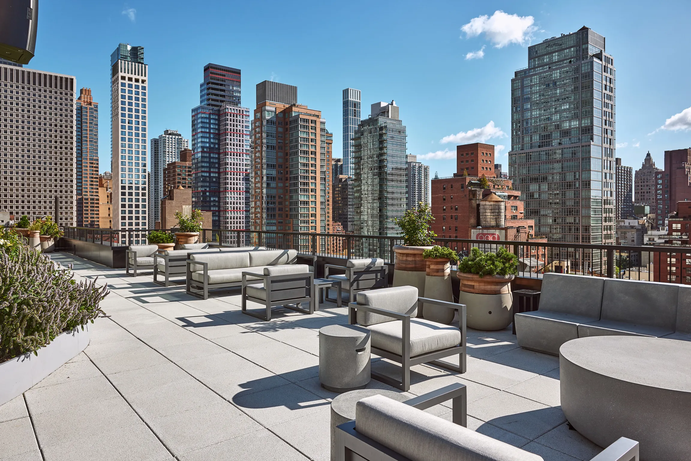 A modern rooftop terrace with benches, offering a view of New York's skyline. Located at 825 Third Ave's 12th floor.