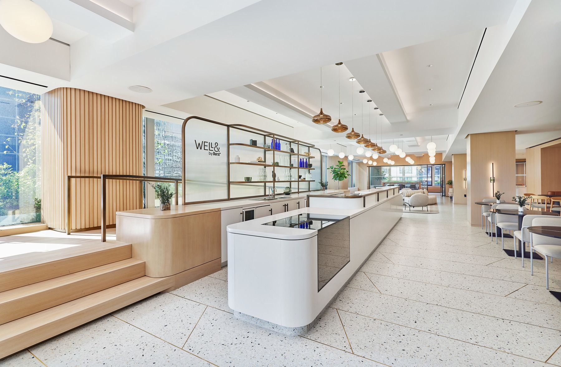 Modern Café & Cocktail Bar featuring a lengthy counter and the Well& by Durst logo on the wall