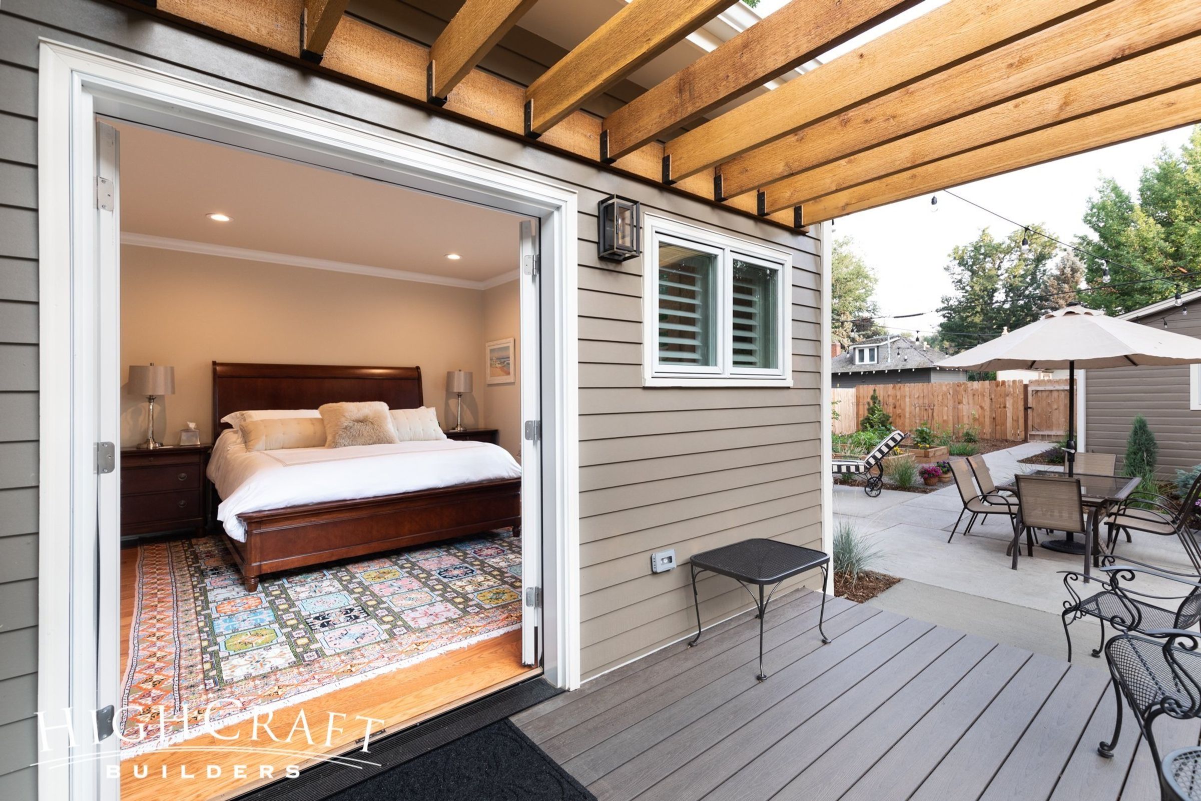 Photo on porch of master bedroom suite, looking in to bed through open french doors