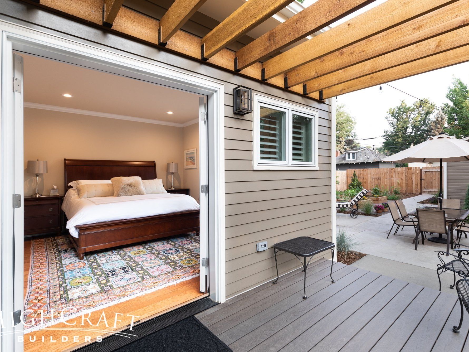 Photo on porch of master bedroom suite, looking in to bed through open french doors