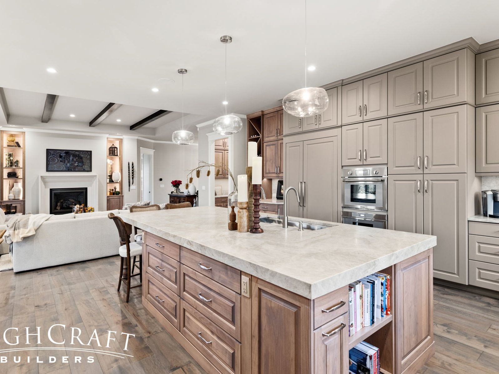 Photo of spacious kitchen remodel with marble island, and light wood-colored custom cabinetry. The color palette is white and light beige with gold hardware accents.