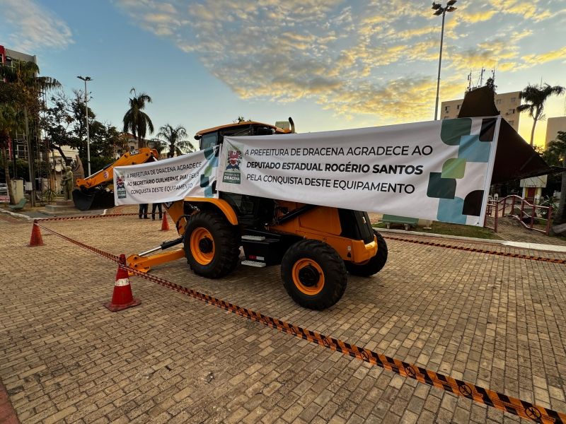 Prefeita Geni Lobo e autoridades ao lado de retroescavadeira em Dracena.