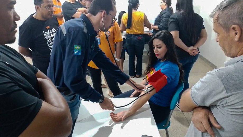 Enfermeira ensina aferição de pressão arterial a voluntários em Três Lagoas.
