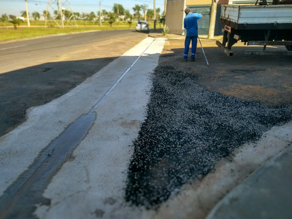Operário constrói sarjetão em Araçatuba para melhorar drenagem urbana.