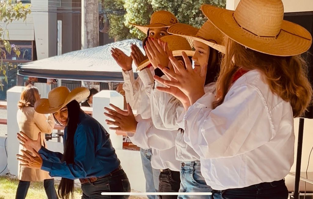 Crianças e adultos dançando catira no evento "Domingo no Museu" em Araçatuba.