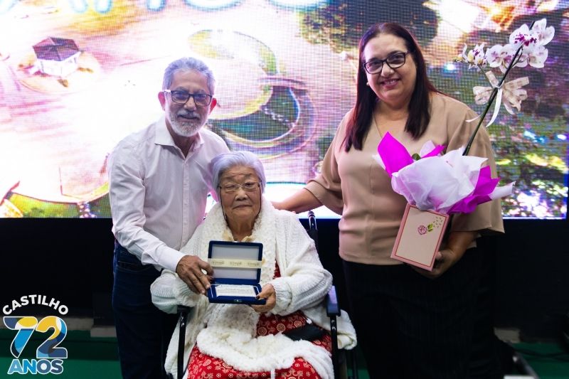 Hilda Mizushima recebe flores na exposição de homenagem a Paulo Mizushima.
