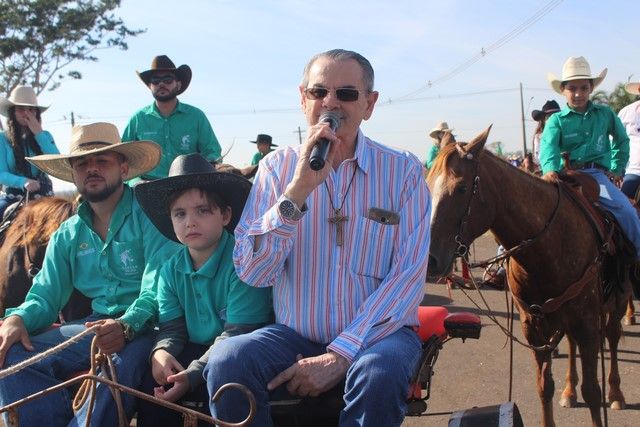 Cavaleiros desfilam na Cavalgada Entre Amigos em Andradina, multidão assiste.