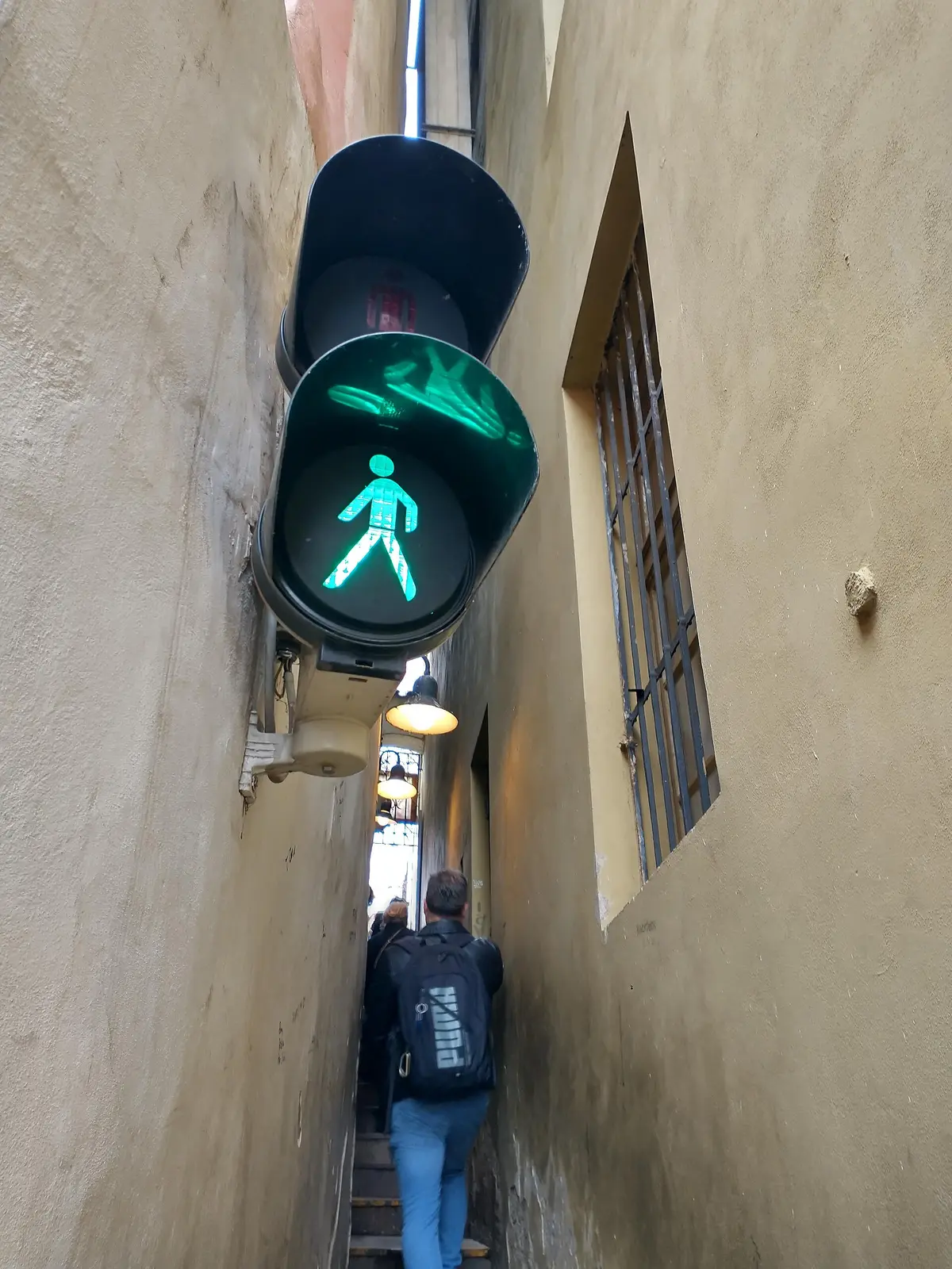 Semáforo de peatones en verde a la entrada de la calle más estrecha de Praga