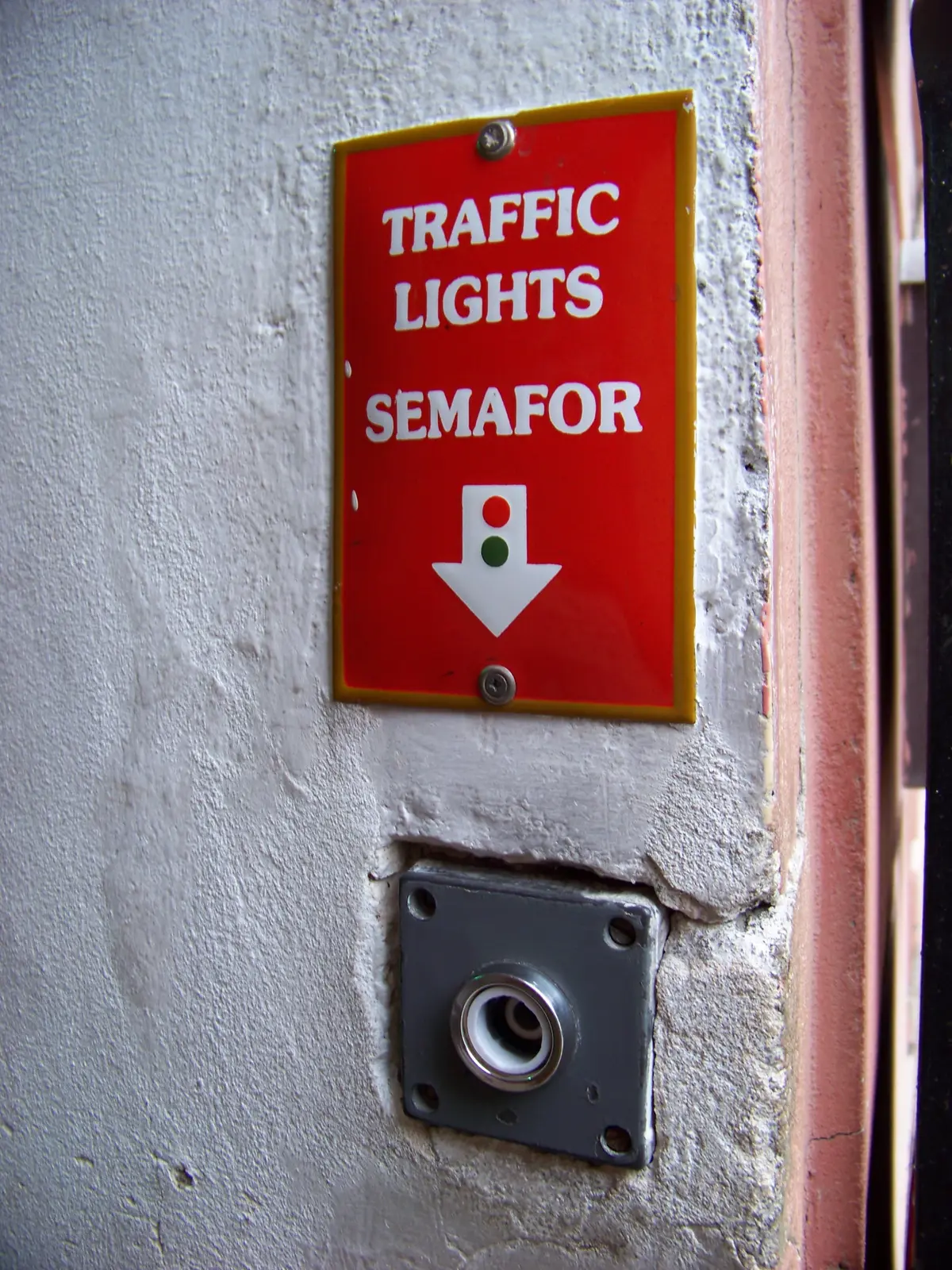 Pulsador del semáforo con el cartel «Traffic lights / Semafor» en la calle más estrecha de Praga