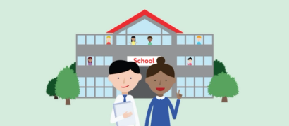 Two teachers standing in front of a school