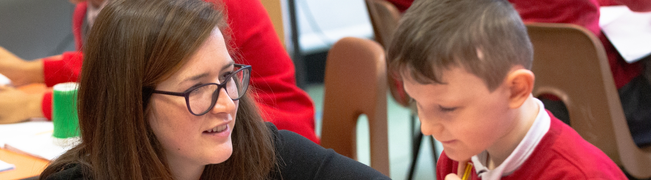 primary accredited school maths teacher helping a young boy