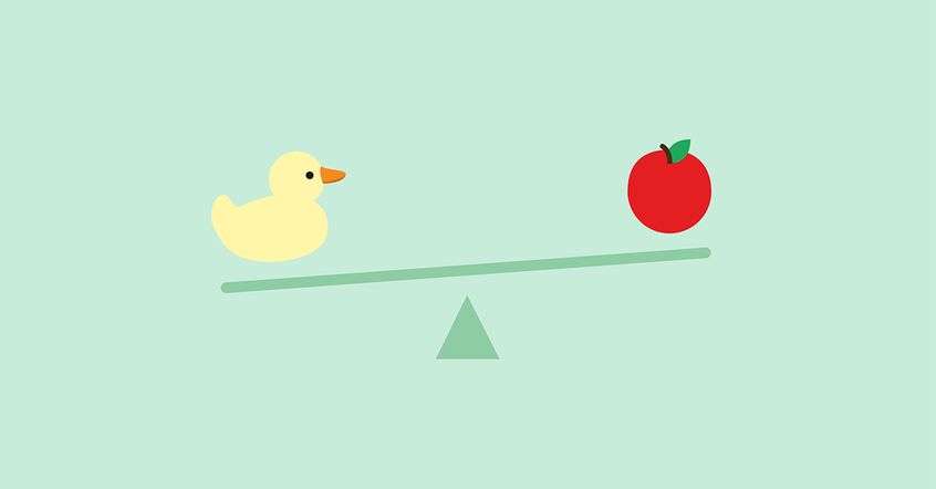 a see-saw with a yellow duck on one side and a red apple on the other, balancing each other