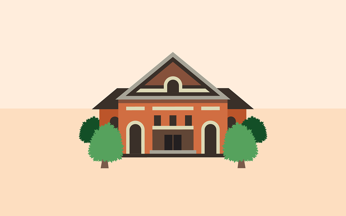 A large symmetrical schoolhouse with 2 trees on either side