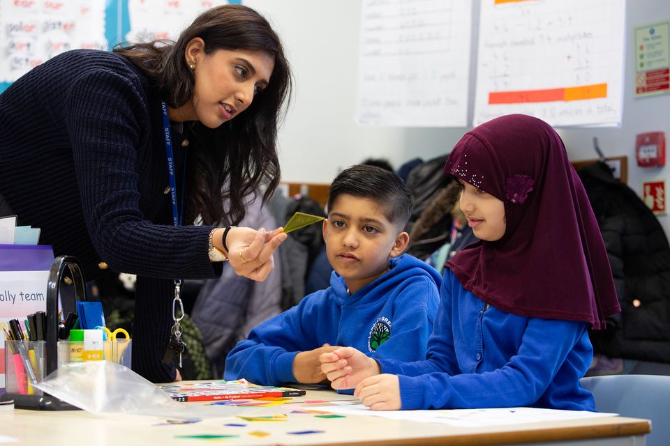 Maths teacher at Langely Green Primary teaching two children.