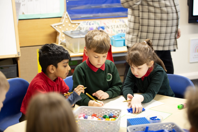Three pupils working together on maths.