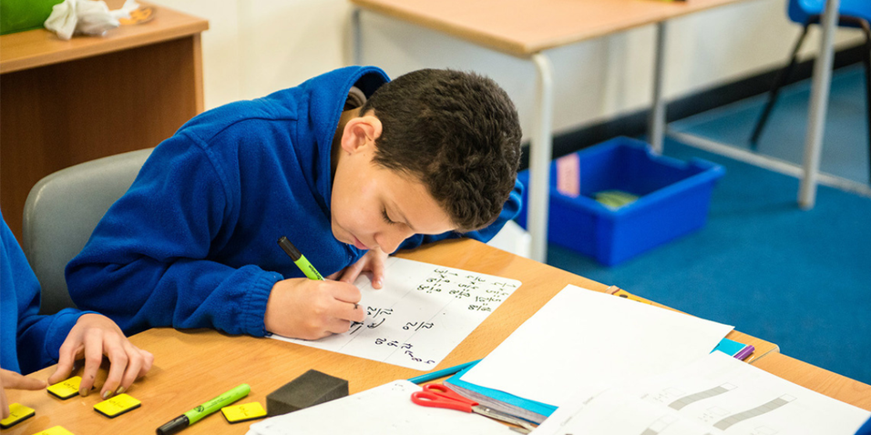 Canadian student writing math on a whiteboard.