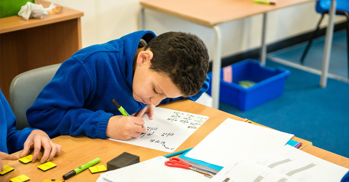 Canadian student writing math on a whiteboard.