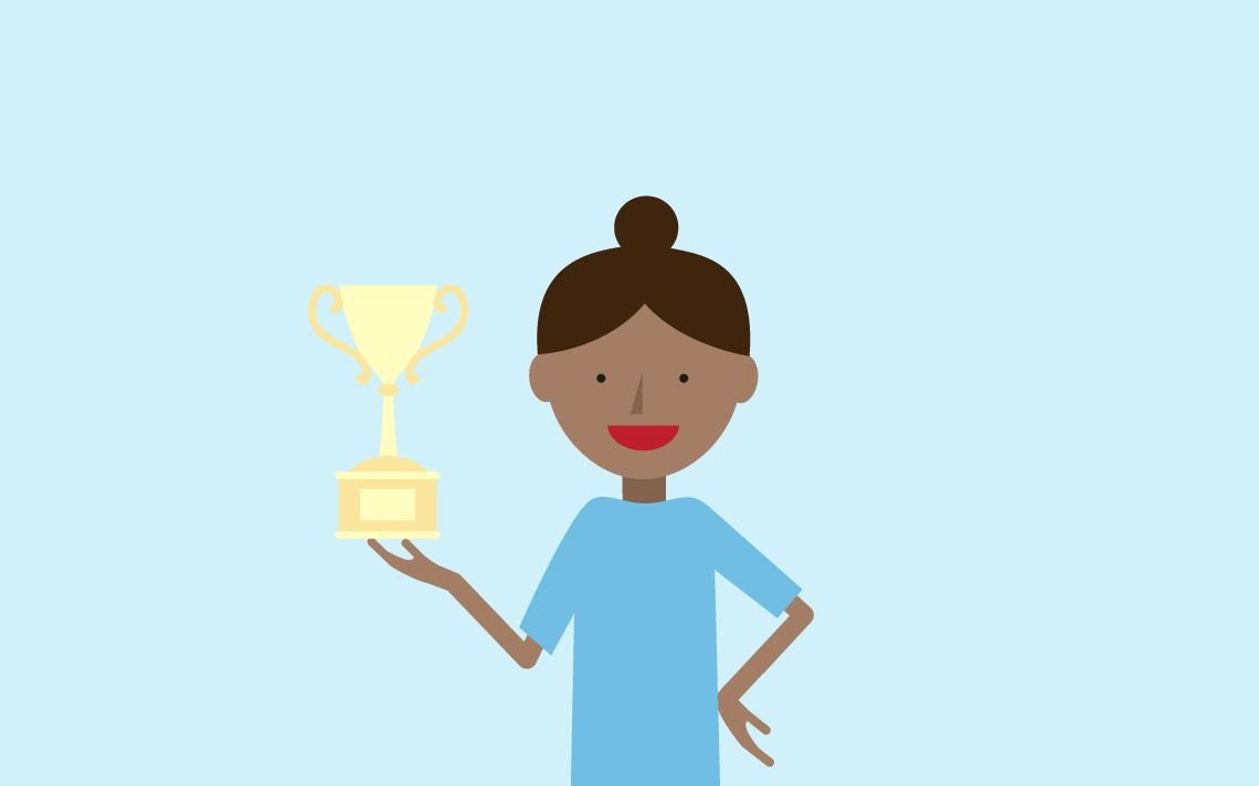 A maths specialist holding a gold trophy in her right hand