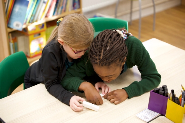 Two young female students working together on math.