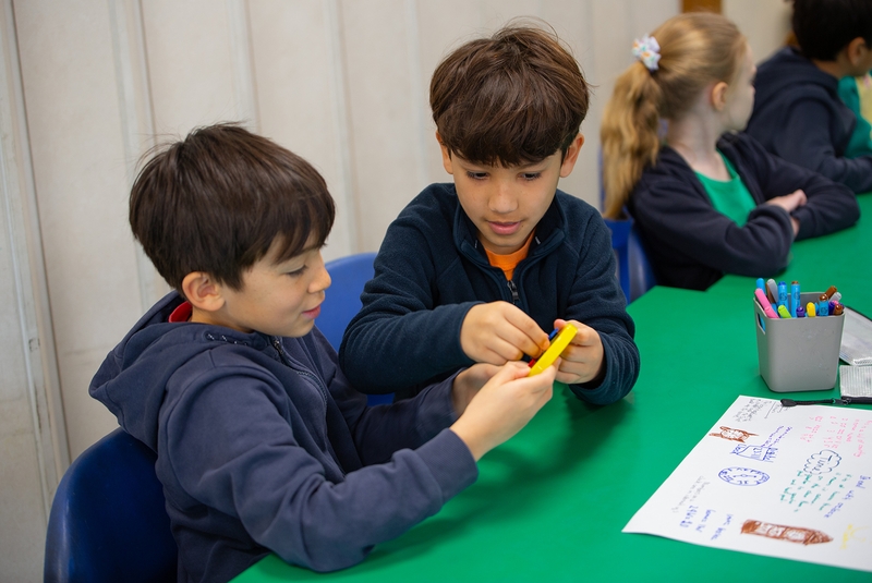Two young boys working together with manipulatives.