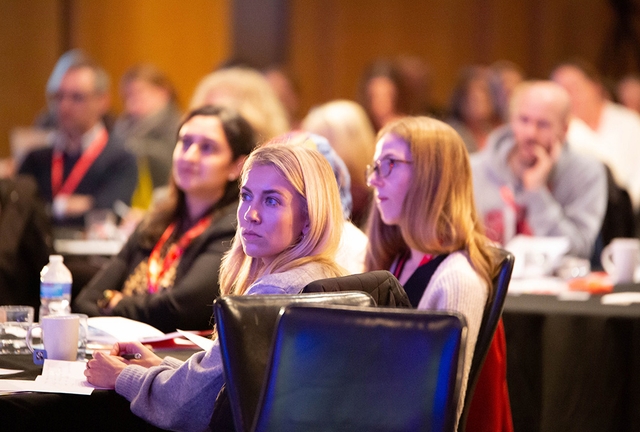 attendees listen attentively and take notes during a professional conference session