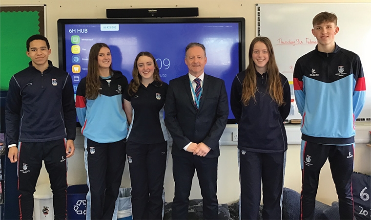 Five Maths — No Problem! mastery programme alumni standing with their teacher Roger Hitchin