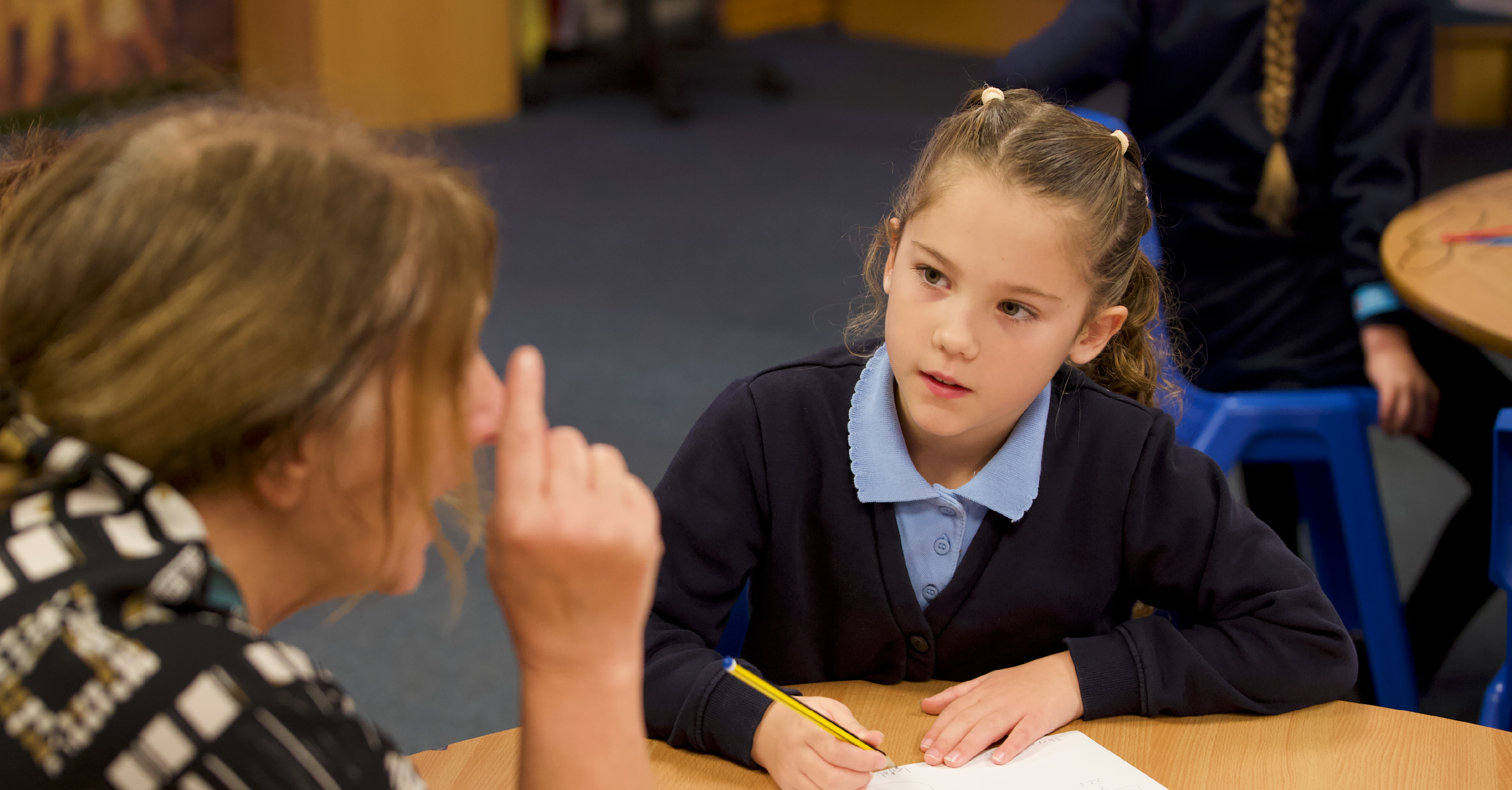 Teacher assisting a pupil who appears confused.