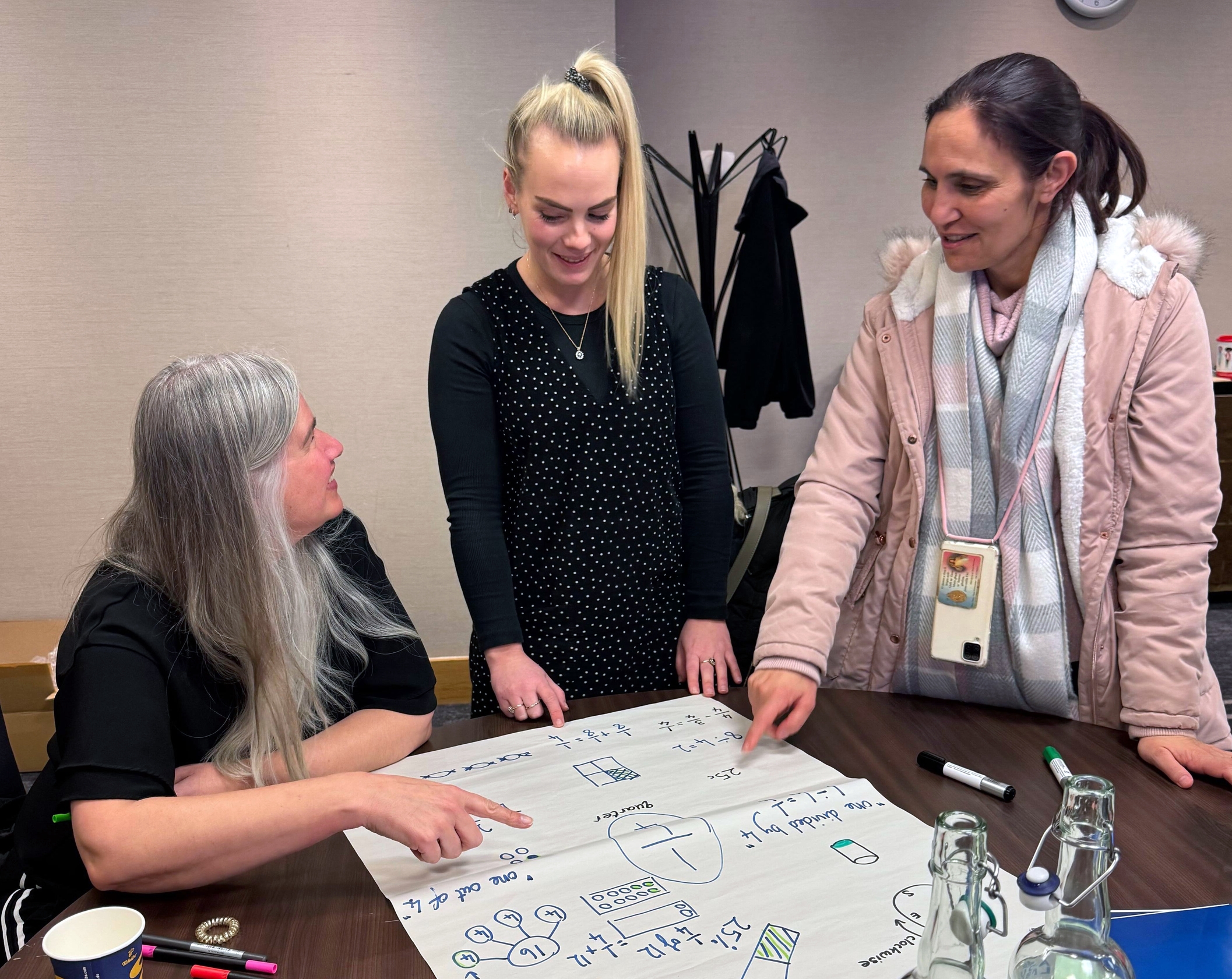 Suzi Telford speaking to two teachers about maths.