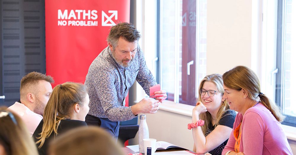 Our Maths — No Problem! instructor Adam Gifford working with four other educators at a CPD event