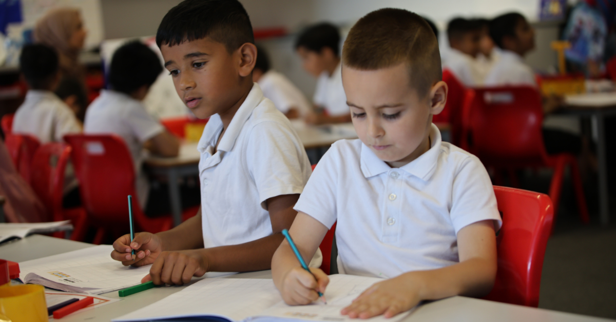 Two pupils writing in maths journal at Eastbury School