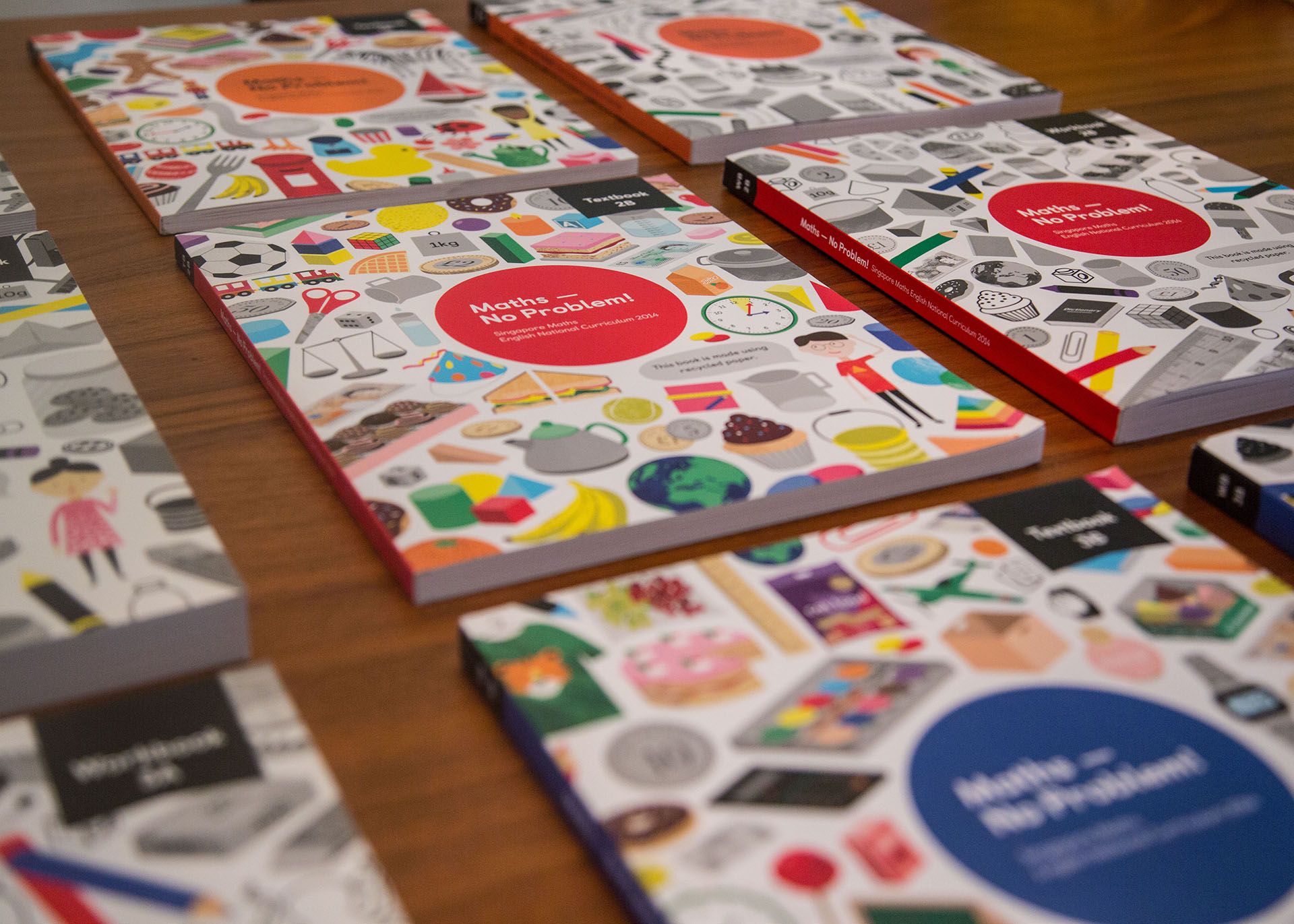 A table with Maths — No Problem! textbooks and workbooks on it