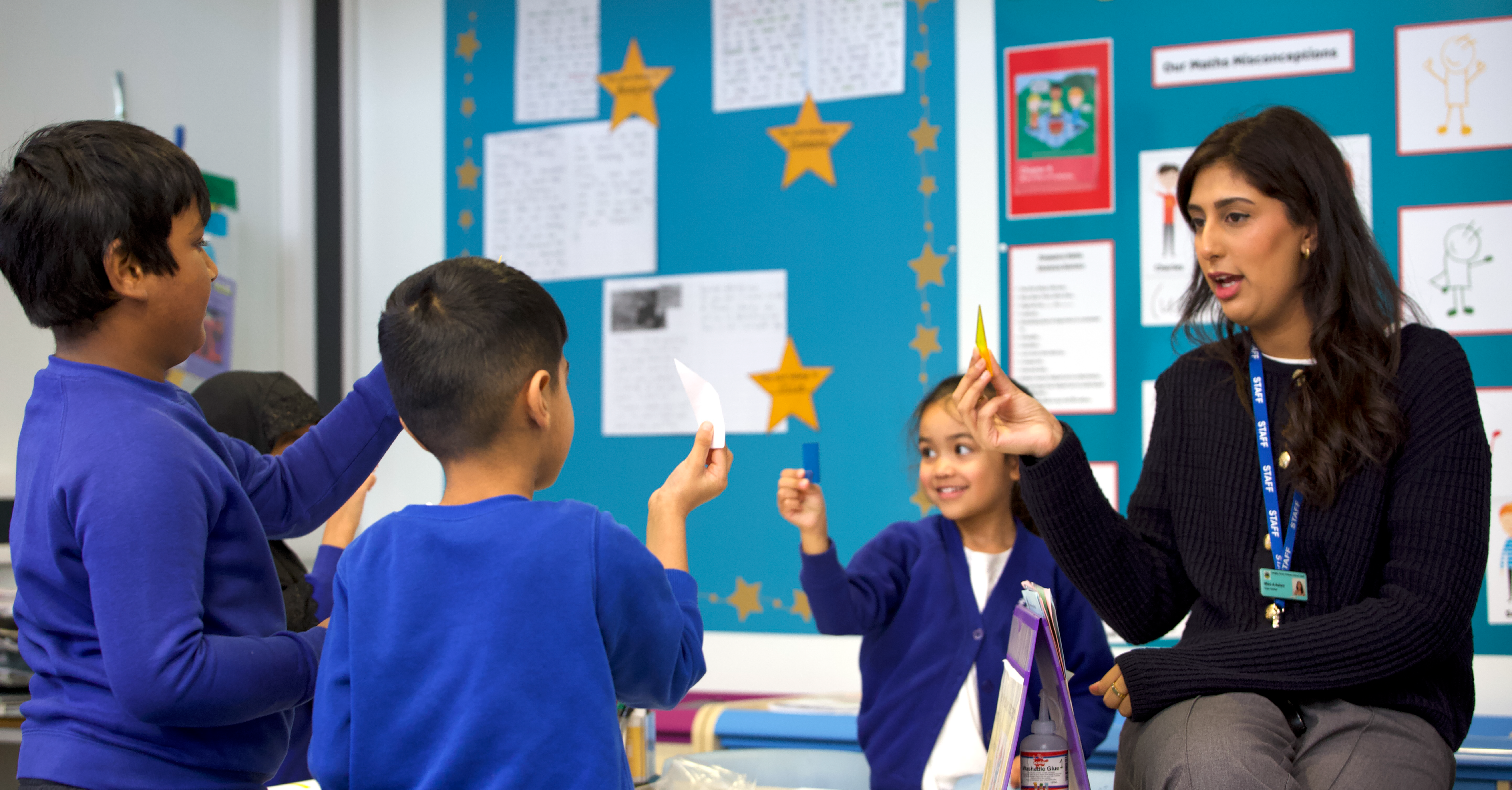 Teacher with pupils holding up cards.