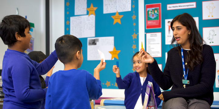 Teacher with pupils holding up cards.