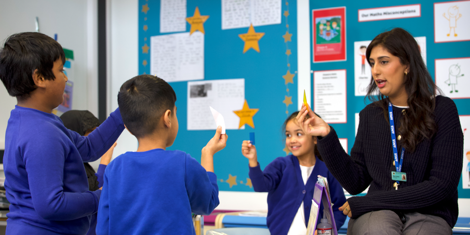 Teacher with pupils holding up cards.