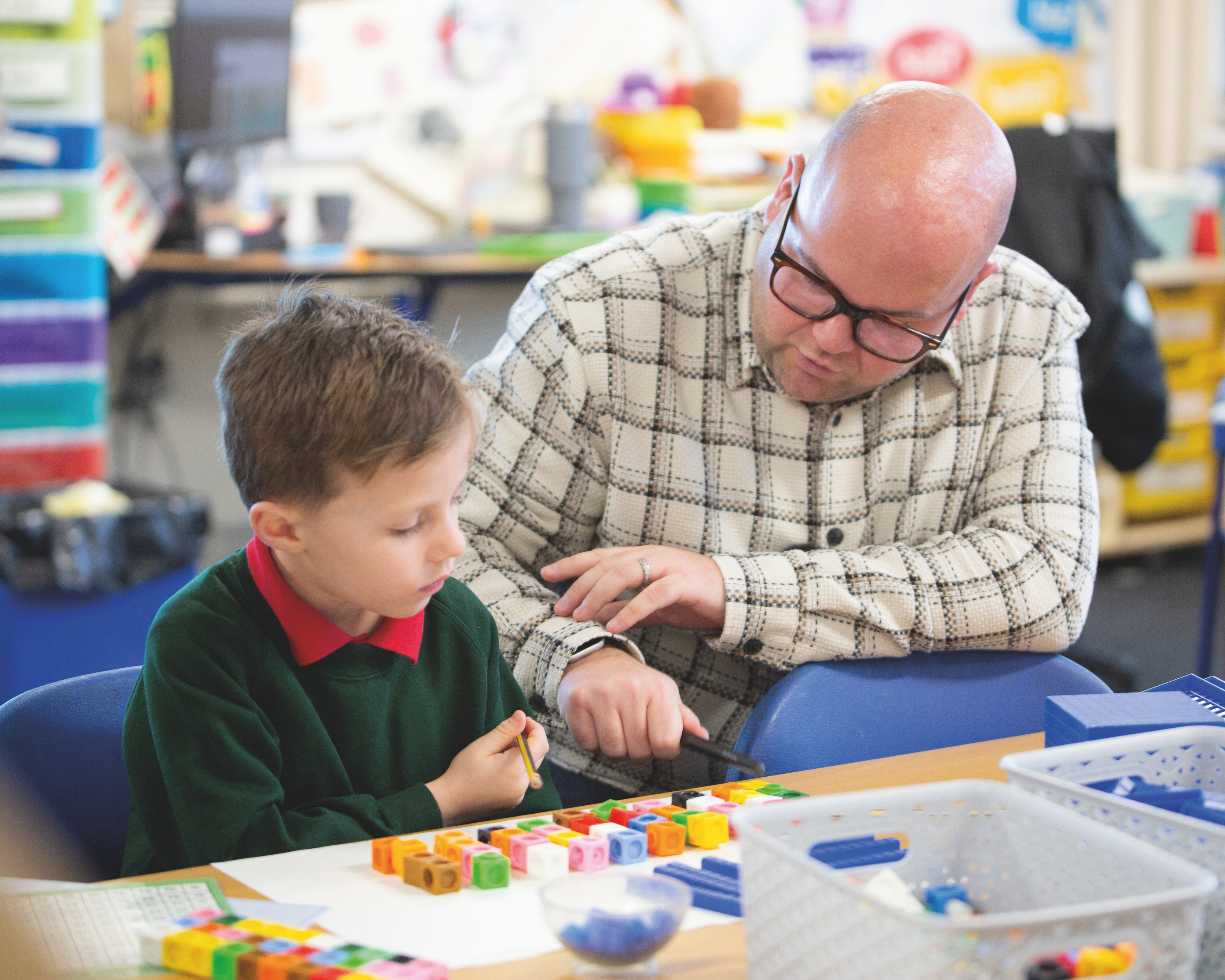 School teacher working with a pupil with manipulatives