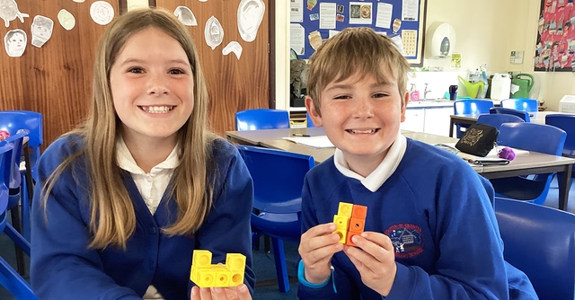 Happy pupils showing manipulatives