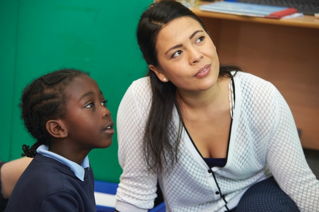 Teacher sitting next to a student.